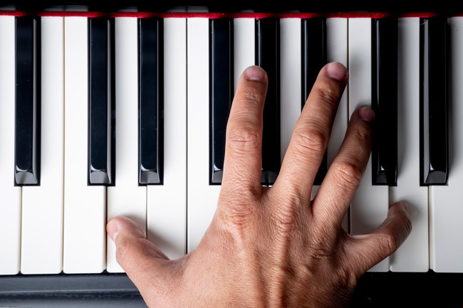 ピアノの鍵盤に広げた手