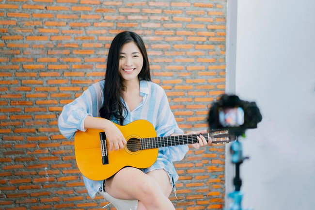 ギターを持つ笑顔の女性